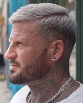 Ben Gillooly Bleached white hair with a hard part finished with a fade