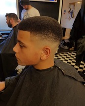 High and tight Afro fade with rounded top and sharp line out