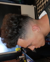 Mid fade and trim Mid skin fade, curls trimmed and shaped into a high level loose flat top