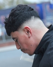 Scratches Low and heavy skin fade, blunt fringe loads of texture on top and scratches going through 