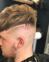 skin fade This is a skin fade with a creative design, and a messy textured style on top.