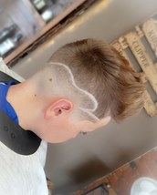 Summer time Skinfade Low skinfade with a long textured top and some squiggles for the summer.