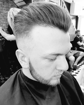 weekend warrior mid skin fade with high pomp style top. beard cut and shaped.